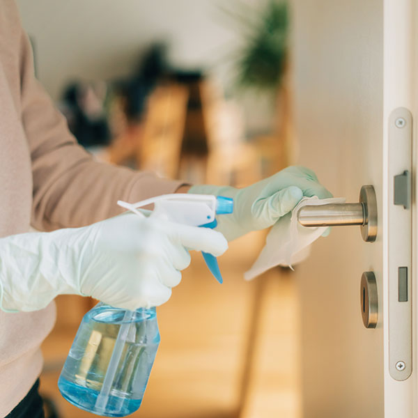 Cleaning a door handle with a disinfection spray
